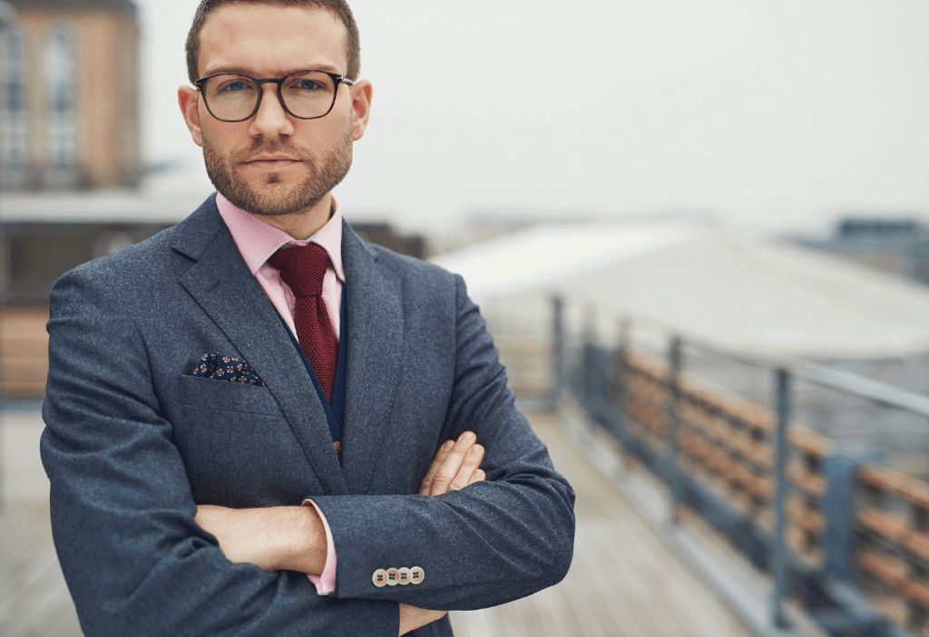 man in suit with arms folded